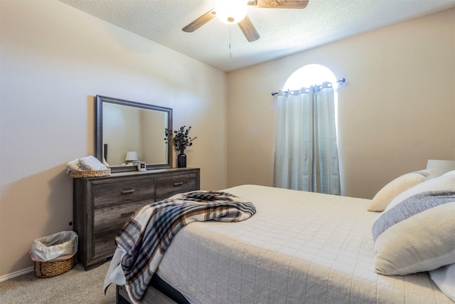 bedroom with light carpet, ceiling fan, and a textured ceiling