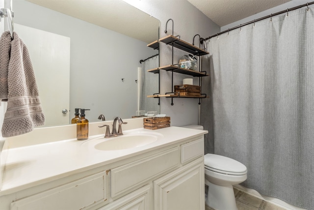 bathroom with vanity, toilet, and a textured ceiling