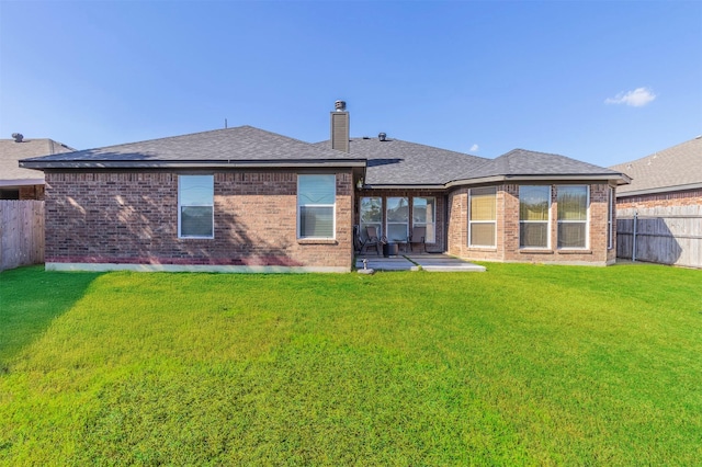 rear view of house featuring a yard and a patio area