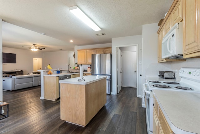 kitchen featuring sink, dark hardwood / wood-style flooring, stainless steel appliances, a kitchen island, and light brown cabinetry