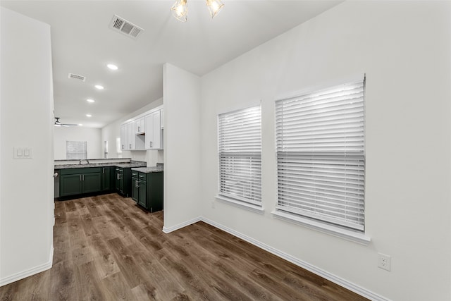 kitchen featuring white cabinets, ceiling fan, hardwood / wood-style flooring, sink, and green cabinetry