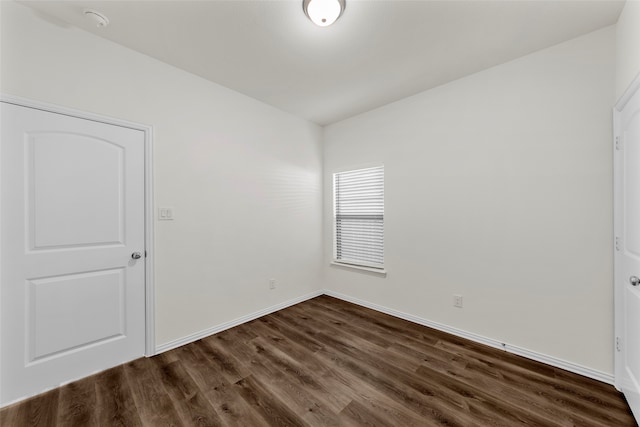 empty room with dark hardwood / wood-style flooring