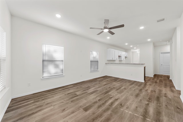 unfurnished living room featuring hardwood / wood-style flooring and ceiling fan