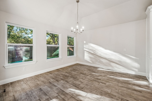 unfurnished dining area featuring a chandelier and wood-type flooring