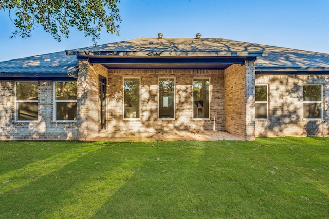 back of property featuring a yard and a patio