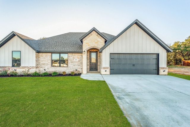 modern inspired farmhouse featuring a front lawn and a garage