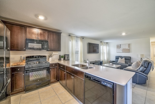 kitchen with kitchen peninsula, sink, light tile patterned floors, and black appliances