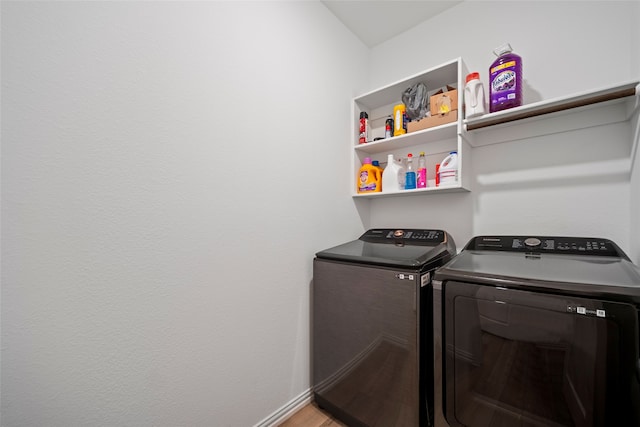 clothes washing area featuring washer and clothes dryer and hardwood / wood-style flooring