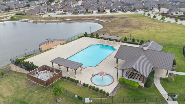 view of swimming pool featuring a patio area, a yard, and a water view