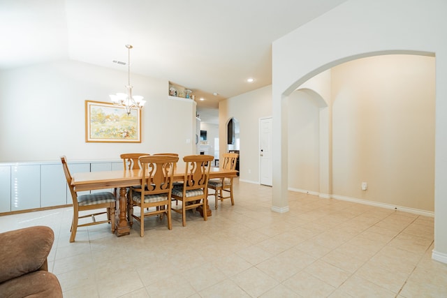 dining space with a notable chandelier, lofted ceiling, and light tile patterned floors