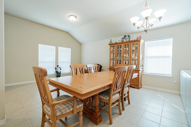 dining room featuring light tile patterned flooring, lofted ceiling, and an inviting chandelier