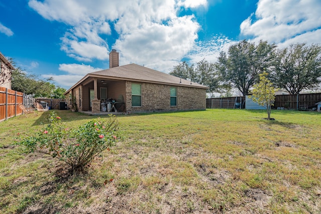 602 Tumbleweed Dr, Forney, TX 75126 - back of house with a chimney, a fenced backyard, brick siding, and a patio