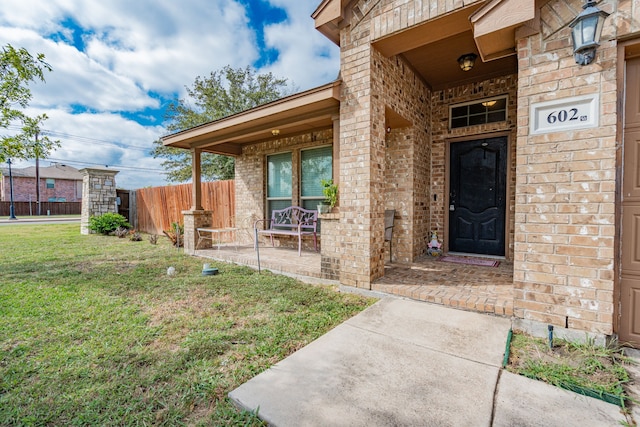 view of exterior entry featuring a yard