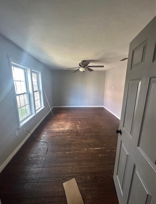 empty room featuring dark hardwood / wood-style floors, a textured ceiling, and ceiling fan