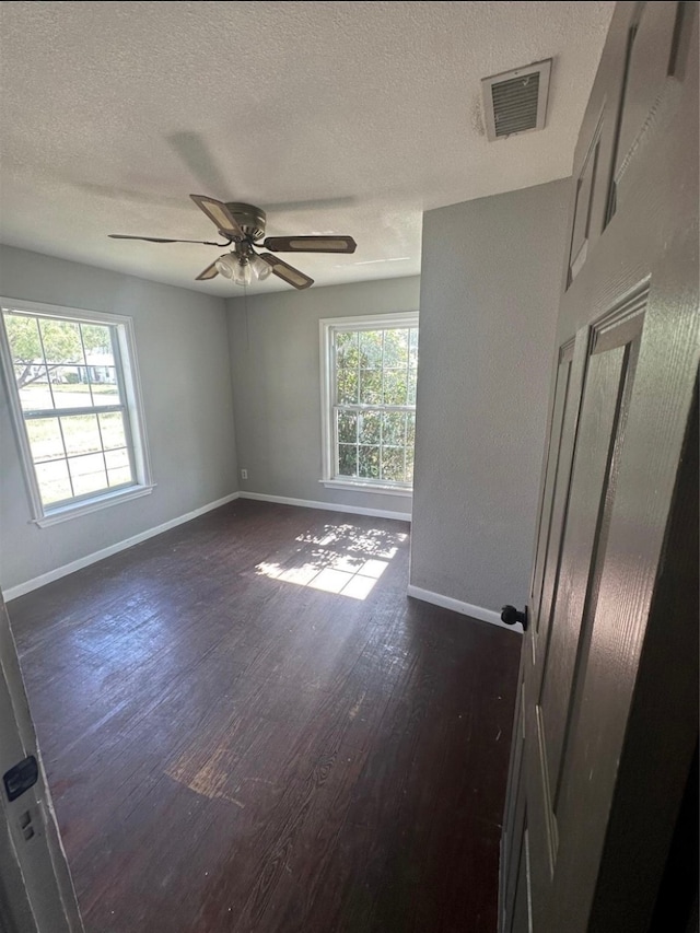 unfurnished room featuring ceiling fan, a textured ceiling, and dark hardwood / wood-style flooring