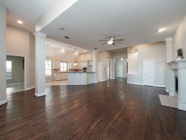 unfurnished living room with ceiling fan and dark wood-type flooring