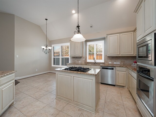 kitchen with a center island, hanging light fixtures, backsplash, lofted ceiling, and appliances with stainless steel finishes