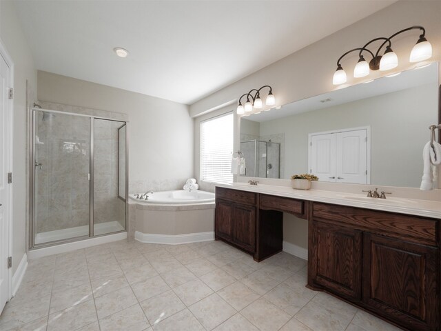 bathroom featuring plus walk in shower, vanity, and tile patterned flooring