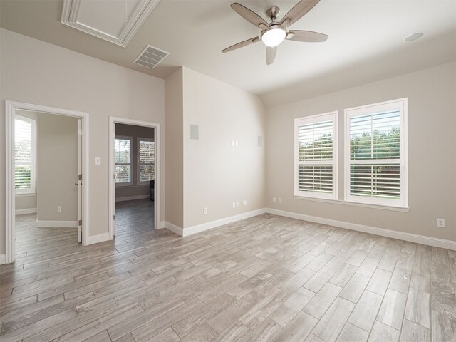 spare room with plenty of natural light, ceiling fan, and light wood-type flooring