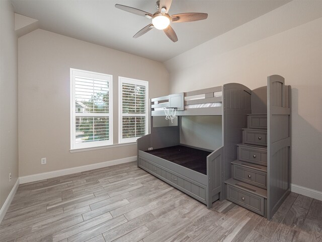 bedroom with light wood-type flooring, vaulted ceiling, and ceiling fan