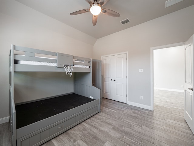 unfurnished bedroom featuring ceiling fan, light hardwood / wood-style flooring, and vaulted ceiling