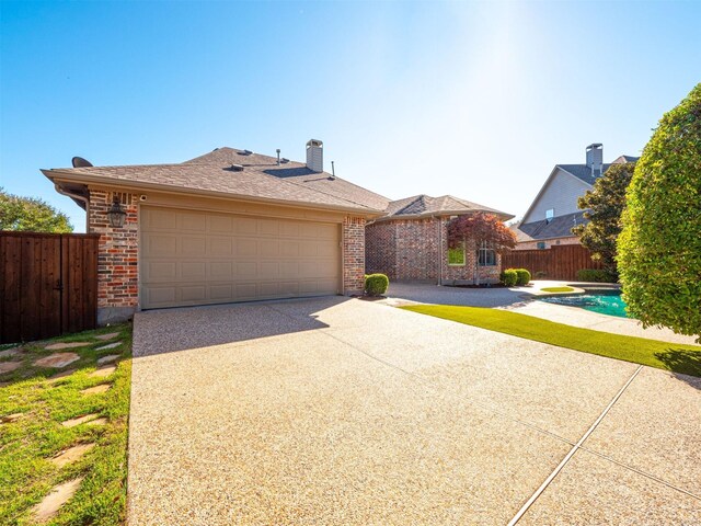 view of front facade with a fenced in pool, a garage, and a patio area