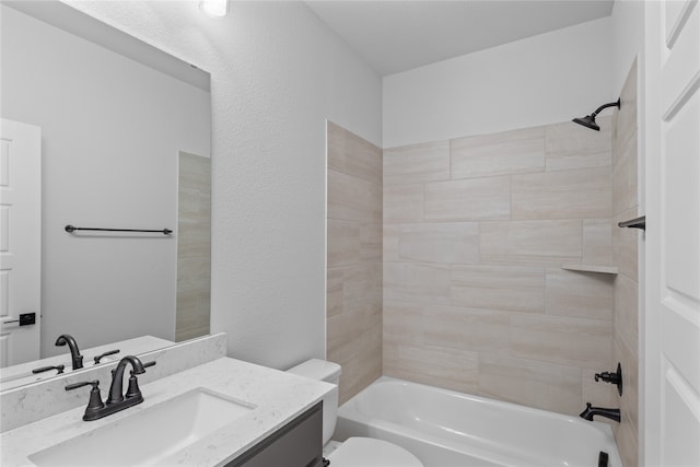 full bathroom featuring tiled shower / bath, vanity, and toilet