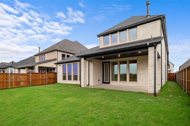 back of property with a patio area and a lawn