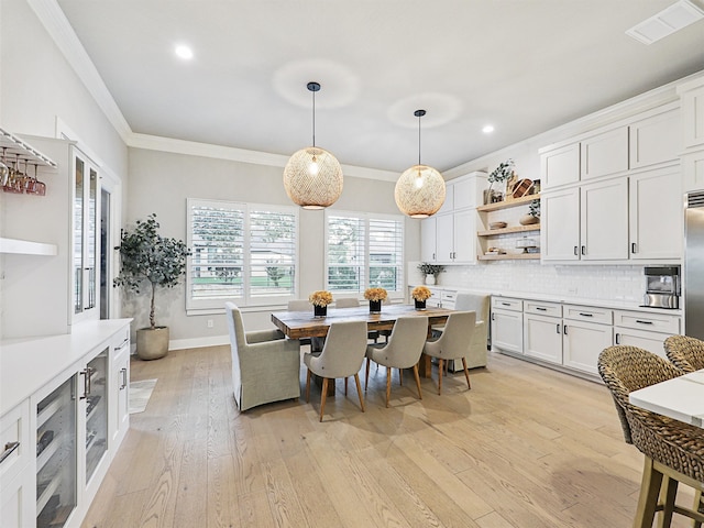 dining room with light hardwood / wood-style flooring and crown molding