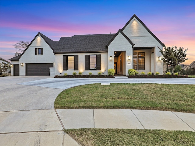 modern inspired farmhouse featuring a garage and a lawn