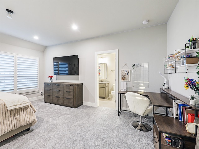 bedroom with connected bathroom and light colored carpet