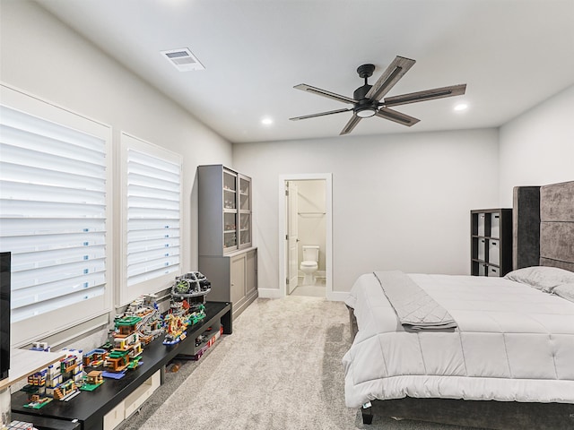 bedroom featuring ensuite bath, light colored carpet, and ceiling fan