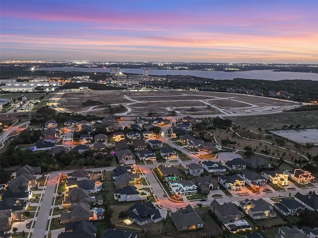 aerial view at dusk featuring a water view