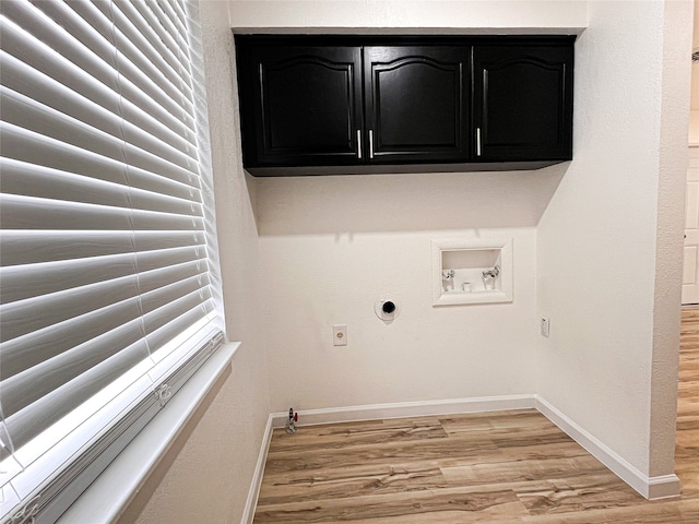 laundry room featuring hookup for a gas dryer, hookup for a washing machine, cabinets, and light hardwood / wood-style floors