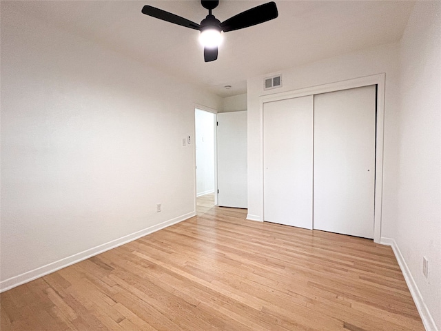 unfurnished bedroom featuring a closet, light hardwood / wood-style floors, and ceiling fan