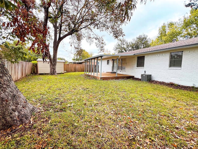 view of yard with a shed, central AC, and a deck