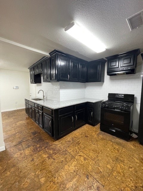 kitchen featuring a textured ceiling, sink, black range with gas cooktop, and backsplash