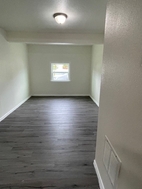 unfurnished room featuring dark wood-type flooring