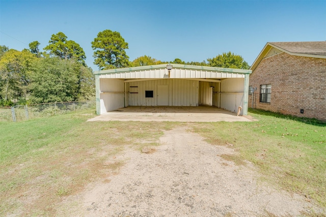 garage with a carport and a yard