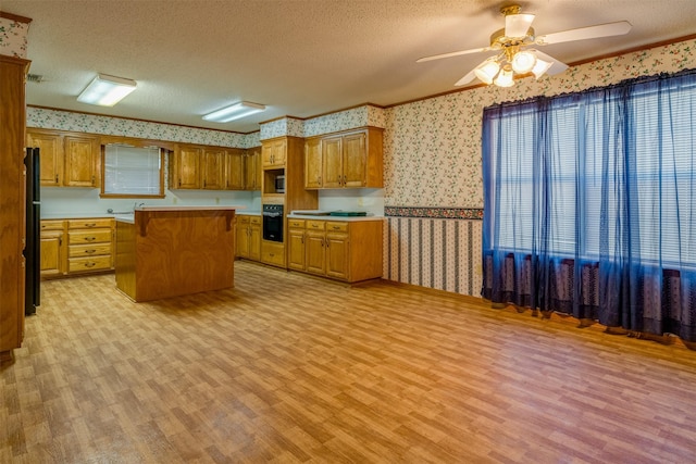 kitchen with a center island, ceiling fan, black appliances, a textured ceiling, and light wood-type flooring