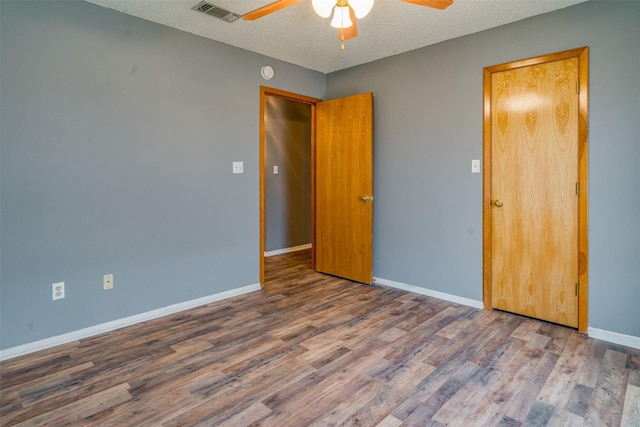 unfurnished bedroom with a textured ceiling, wood-type flooring, and ceiling fan