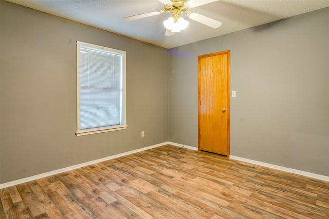 unfurnished room featuring ceiling fan, light hardwood / wood-style floors, and a textured ceiling