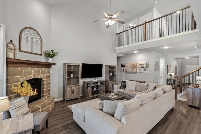 living room featuring dark wood-type flooring, a high ceiling, and ceiling fan