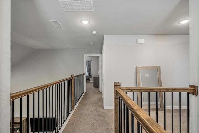 hallway with lofted ceiling and light colored carpet