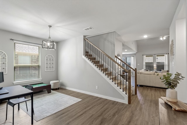 foyer with pool table, a notable chandelier, a wealth of natural light, and dark hardwood / wood-style flooring