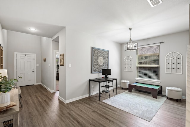 foyer entrance featuring dark hardwood / wood-style flooring, a chandelier, and a barn door