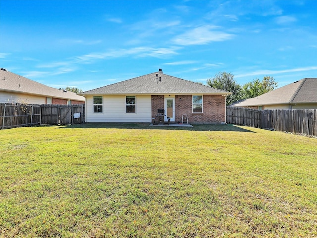 rear view of property featuring a yard