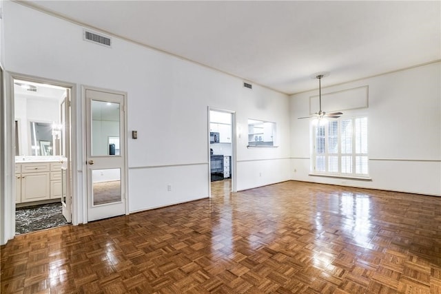 unfurnished living room featuring dark parquet floors and ceiling fan