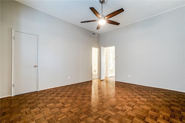 unfurnished room with a towering ceiling, ceiling fan, and dark parquet floors