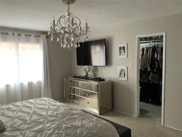 bedroom with a closet, a notable chandelier, and carpet flooring